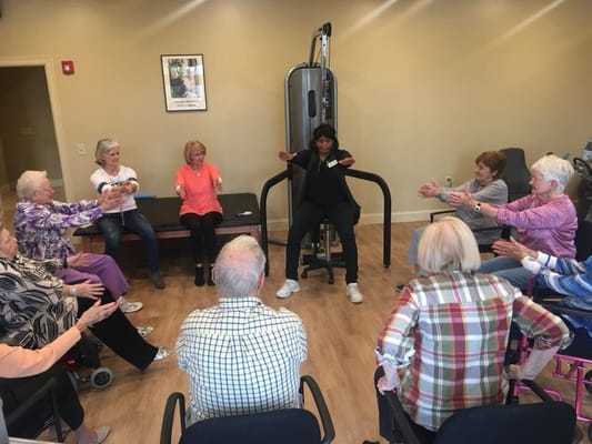 Residents participating in a seated exercise class