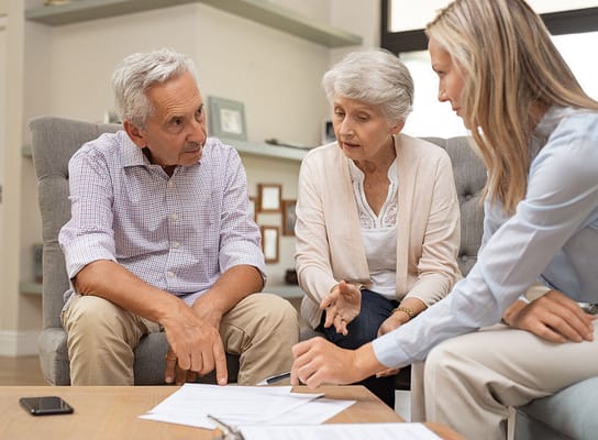 Residents discussing documents in a cozy common area