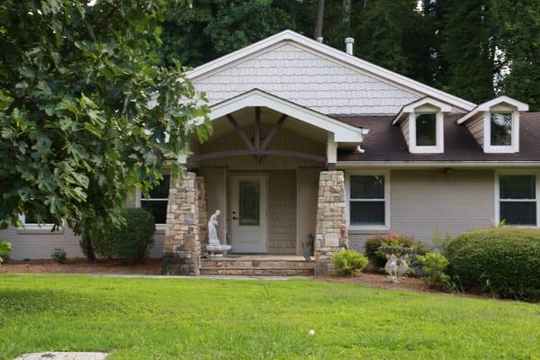 Front entrance of Safe Haven at Lenox Park with stone pillars and greenery