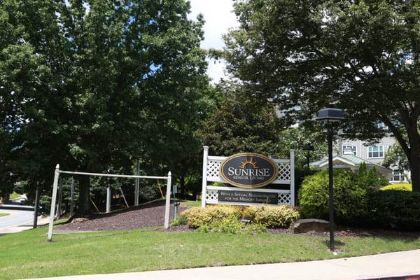 Sign for Sunrise Senior Living with surrounding greenery