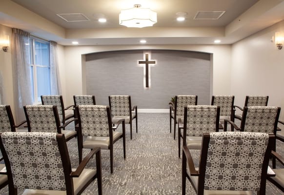 Bright multi-purpose room with chairs and a cross decoration