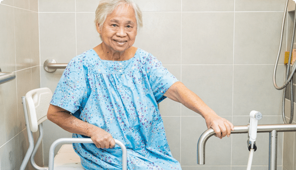 Elderly woman smiling in a shower chair