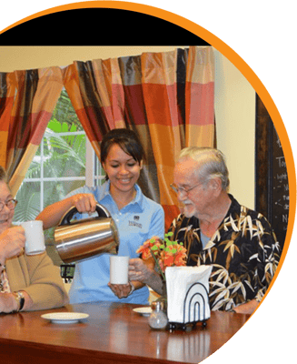 Residents enjoying coffee with staff in a dining area