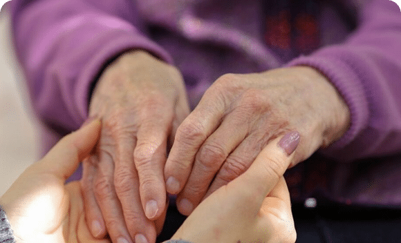 Close-up of elderly hands being held by another person