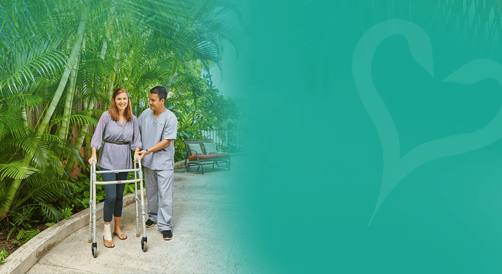 A caregiver assisting a resident in a lush outdoor space