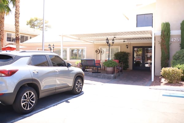 Entrance of Sterling Ridge Senior Living facility with a gray car parked outside.