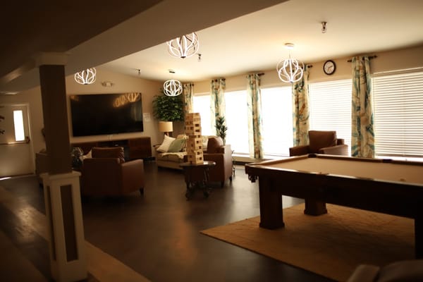 Cozy lounge with a TV, seating, and a game of Jenga.