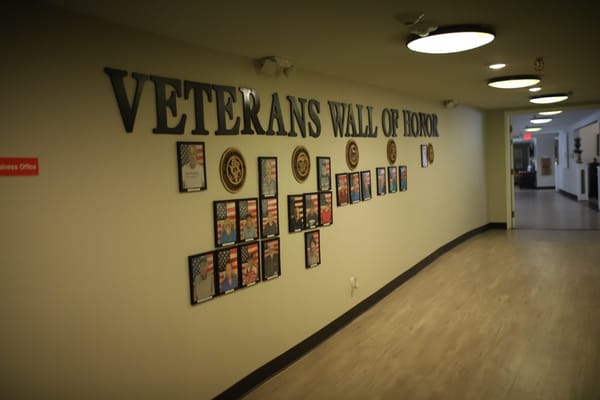 A display featuring the Veterans Wall of Honor with framed portraits and flags