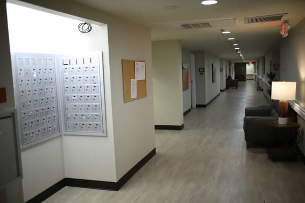 Interior hallway featuring mailboxes and seating area