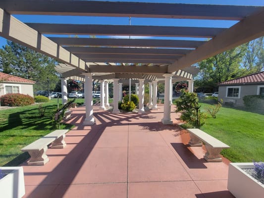 Outdoor walkway with pergola and gardens