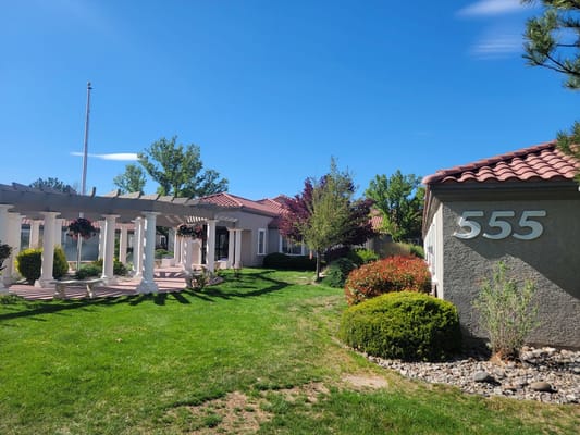 Exterior view of a senior living facility with green landscaping