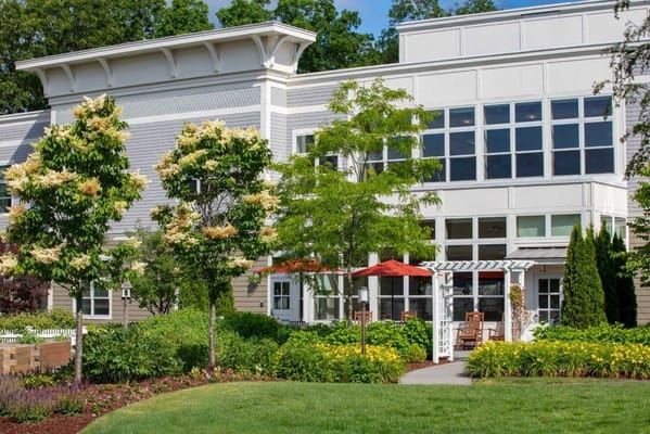 Exterior view of a senior living facility with gardens