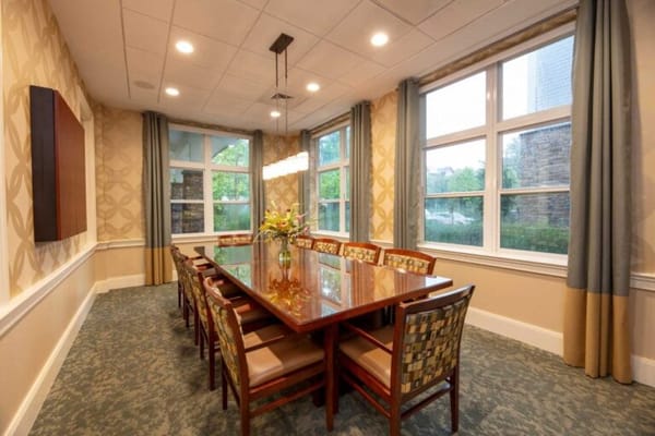 Bright dining room with a large table and flowers
