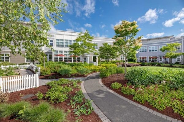 Lush garden path leading to a senior living facility