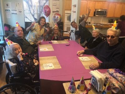 Residents celebrating a birthday party with party hats