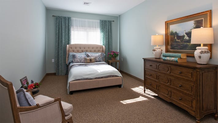 Cozy, well-lit resident room with comfortable furnishings