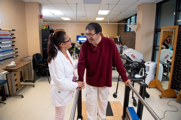 Therapist assisting resident in a rehabilitation setting