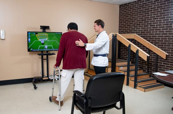 Staff assisting a resident in an activity room