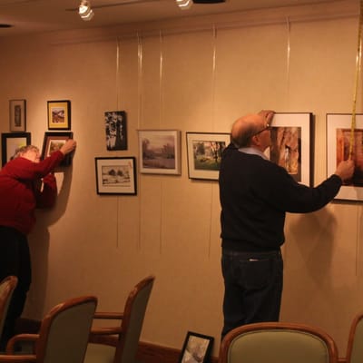 Residents hanging artwork in common area