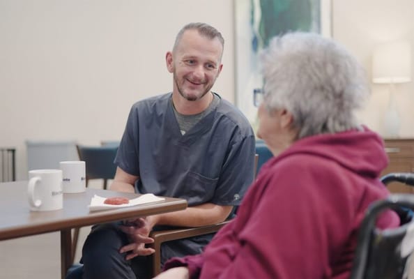 Staff member chatting with a resident over coffee