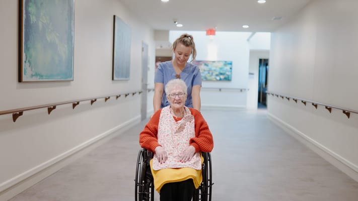 Staff member assisting a resident in a hallway