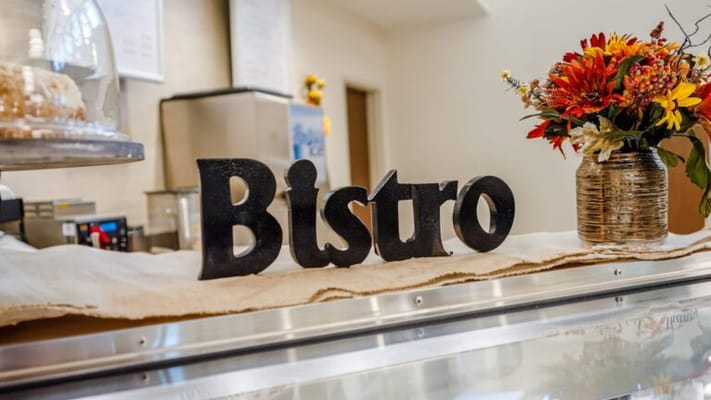Decorative bistro sign with flowers in a dining area