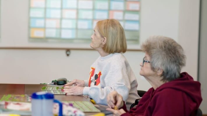 Residents engaged in a bingo game in a common area