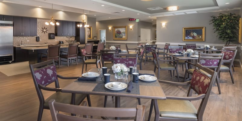 Dining area set for a meal with floral centerpieces