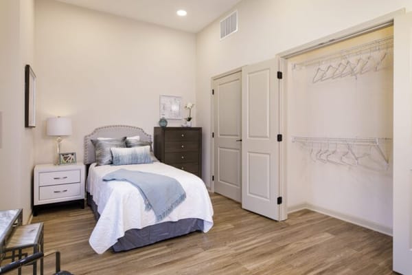 Well-furnished private resident room with a bed and dresser