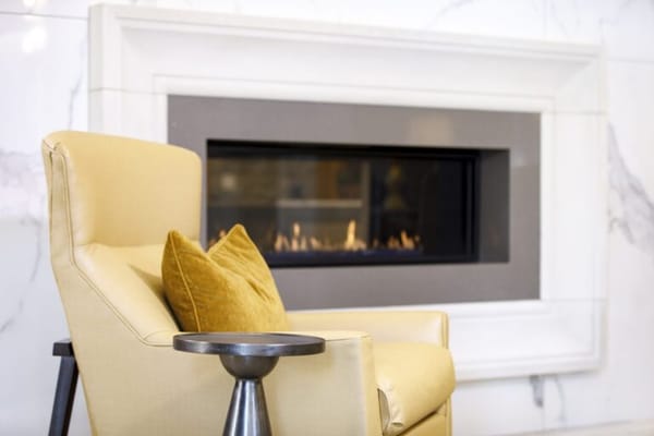 Cozy yellow armchair near a fireplace