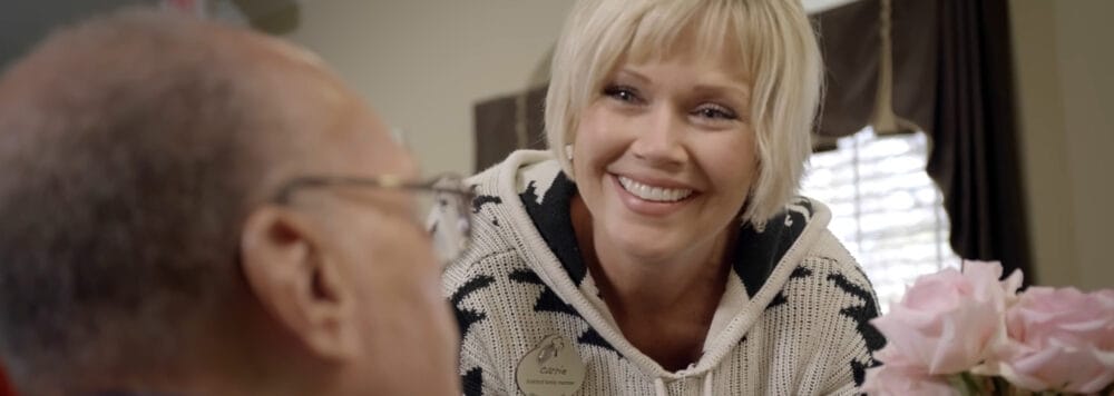 Staff member interacting with a resident, smiling.