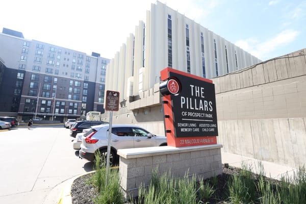 The entrance sign of The Pillars of Prospect Park displaying facility services.