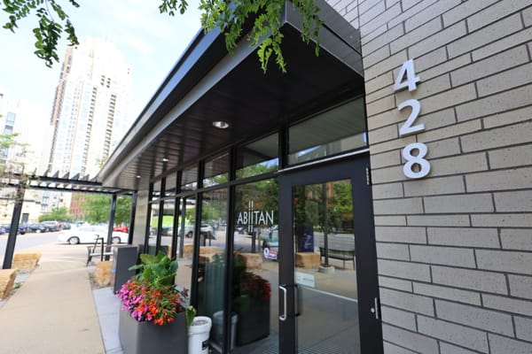 Entrance to a senior living facility with a plant display