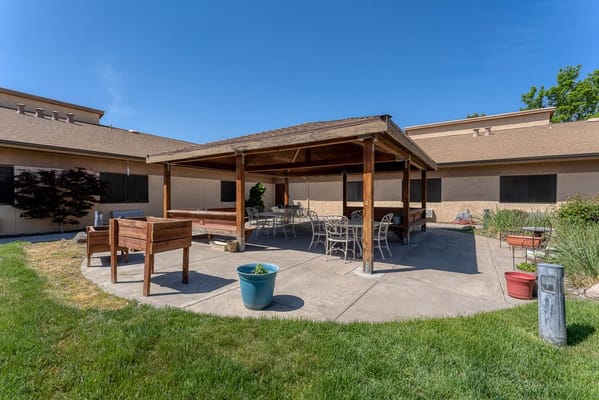 Outdoor covered seating area with tables and chairs