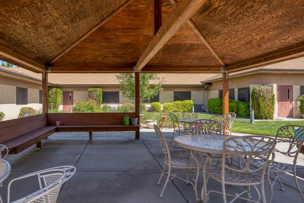 Outdoor shaded seating area with tables and chairs