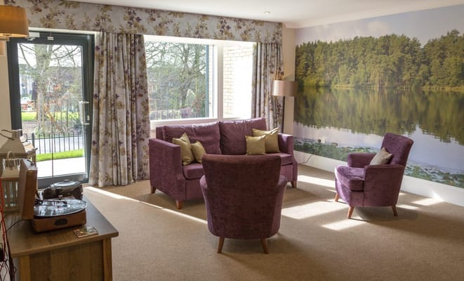 Cozy lounge area with purple sofas and nature mural