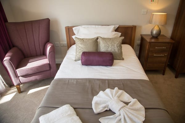 Cozy resident room with a bed and armchair