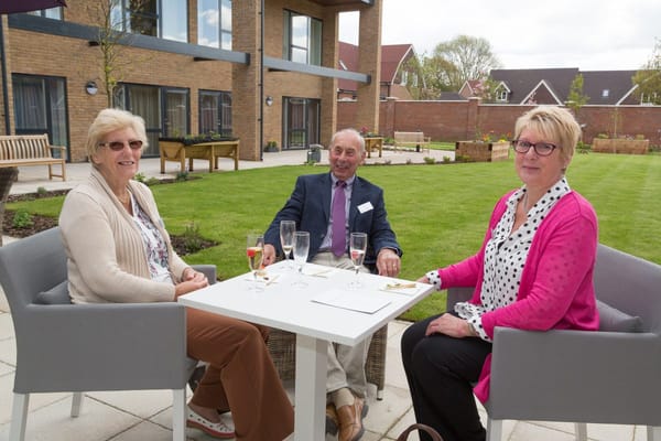 Seniors enjoying drinks outdoors in a garden area