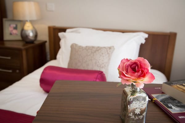 Cozy room with a bedside table and a rose