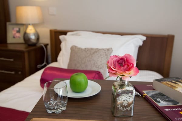 Cozy bedside table with flower and apple