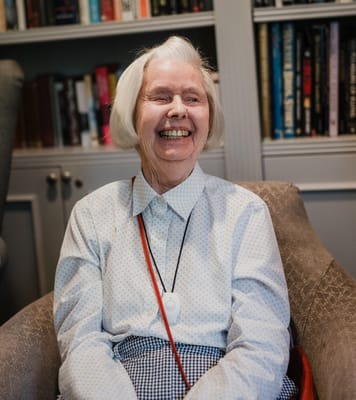 Resident smiling in a cozy lounge setting