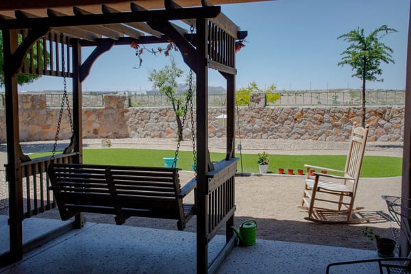 Swing set overlooking a landscaped garden.