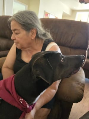 A resident interacting with a dog in a cozy interior setting