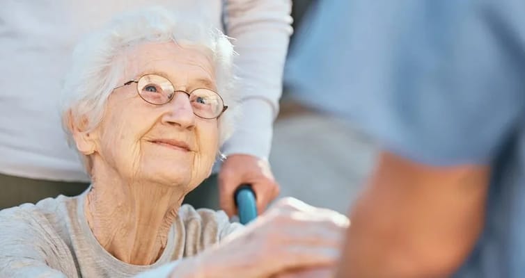 An elderly woman smiling at staff during interaction