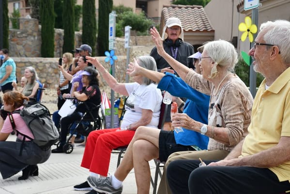 Residents enjoying an outdoor event and waving