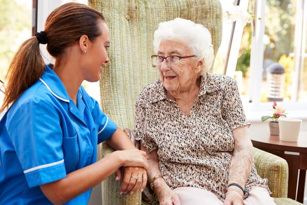 Caregiver talking with an elderly resident in a cozy setting