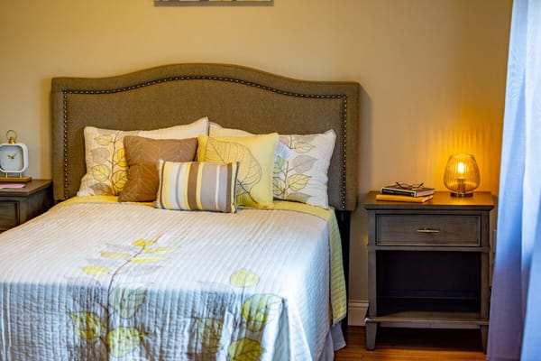 Cozy bedroom with a neatly made bed and bedside lamp