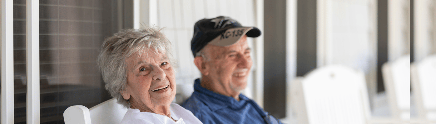 Two residents smiling on a porch