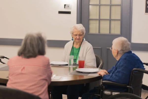 Residents engaged in conversation at a dining table