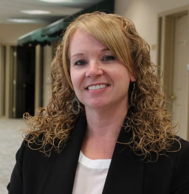 Staff member smiling in a facility hallway